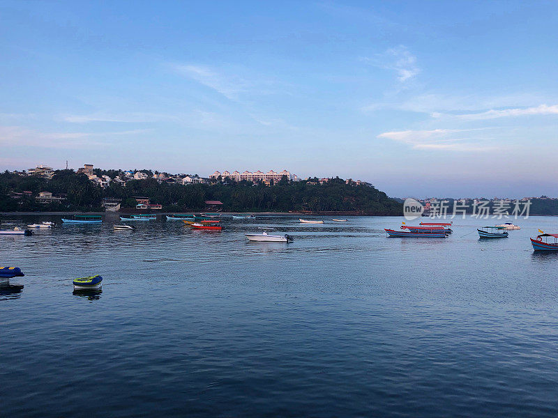 Dona Paula View Point，靠近Miramar海滩，Panaji，果阿，印度南部，有海岸线酒店和度假建筑群俯瞰海景，渔船娱乐和游艇，棕榈树，日落天空，果阿假日度假在高潮